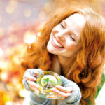 Frau mit Tee im Herbst